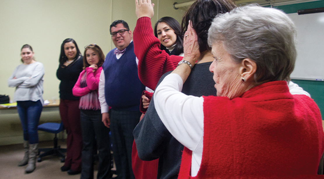 Seven students of varying ages, both men and women, engaging in a listening and get-to-know-each-other exercise. 