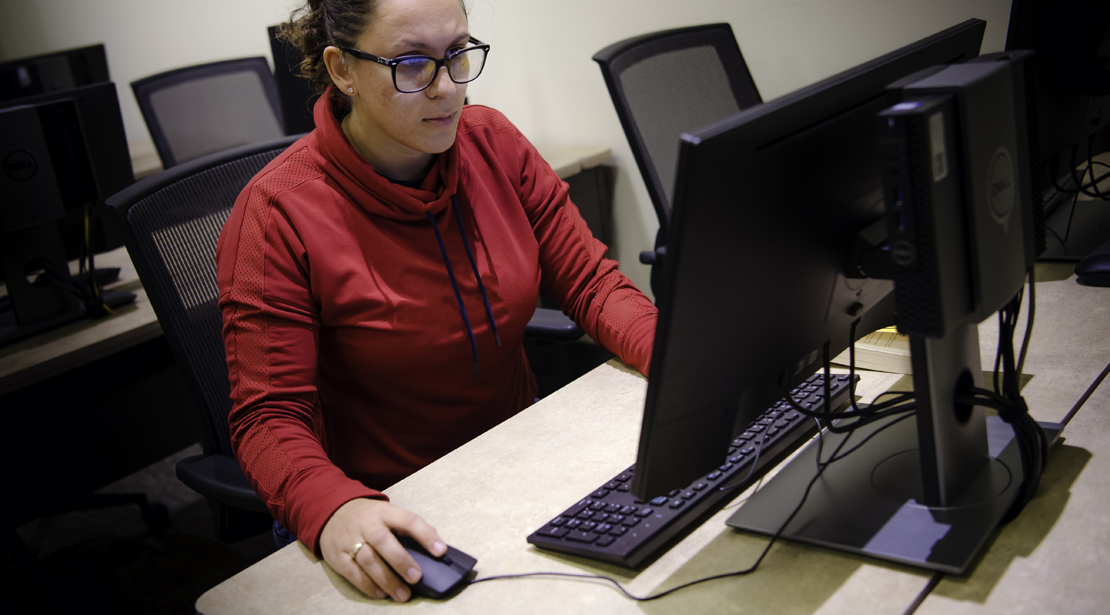 Female student working at a computer in a computer lab.