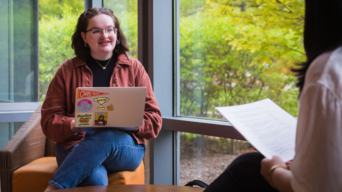 A female student talking with others in a study group.