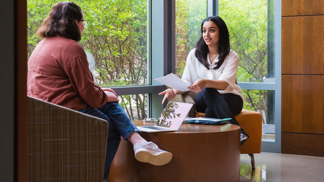 Two students talking in East Academic Building.