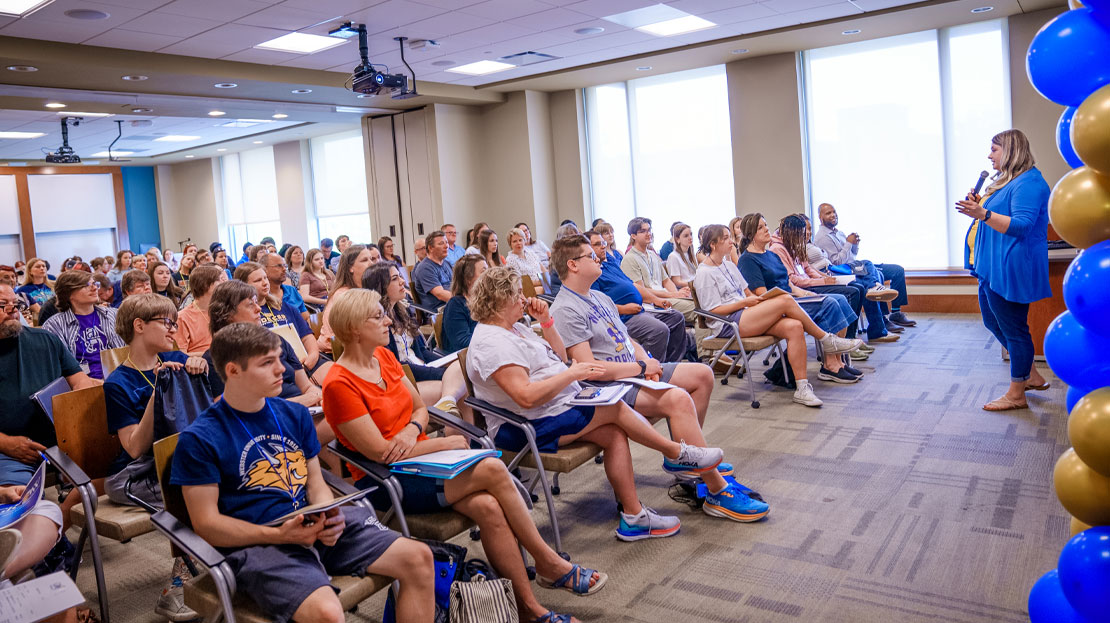 An introduction to the GROW program with high school students filling the audience.