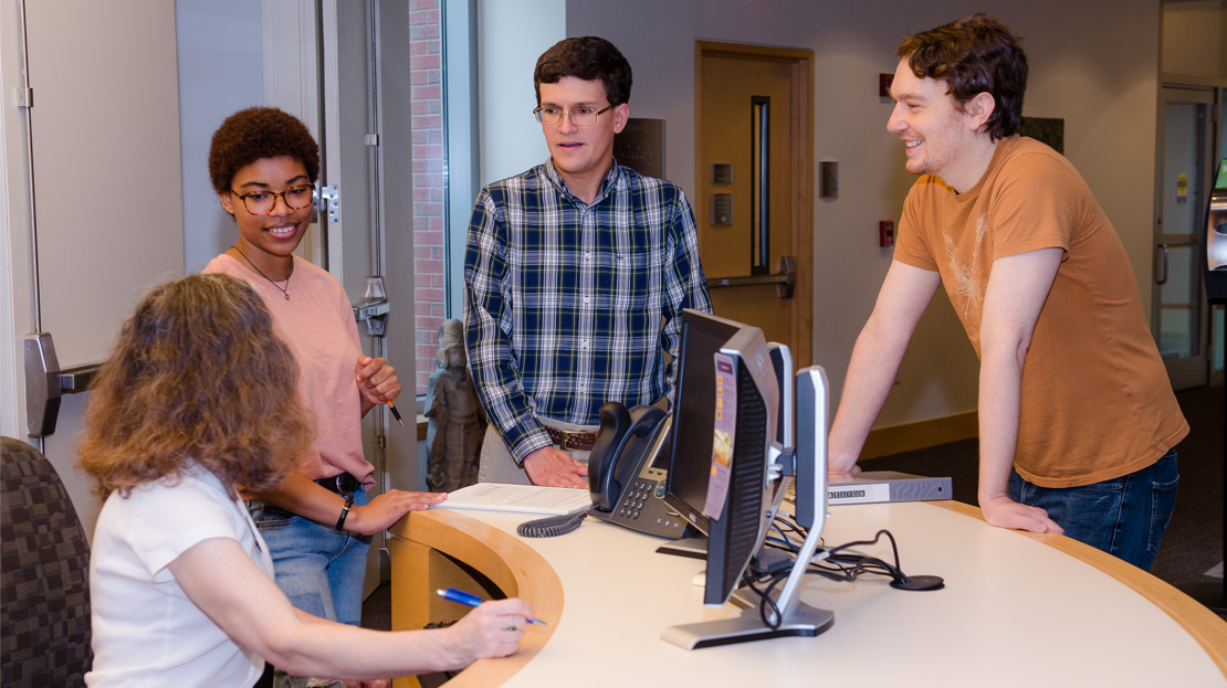 4 students working together around a computer.