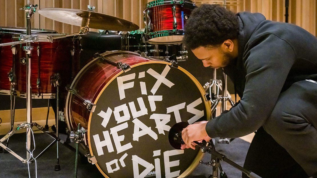 student positioning microphone in front of drum