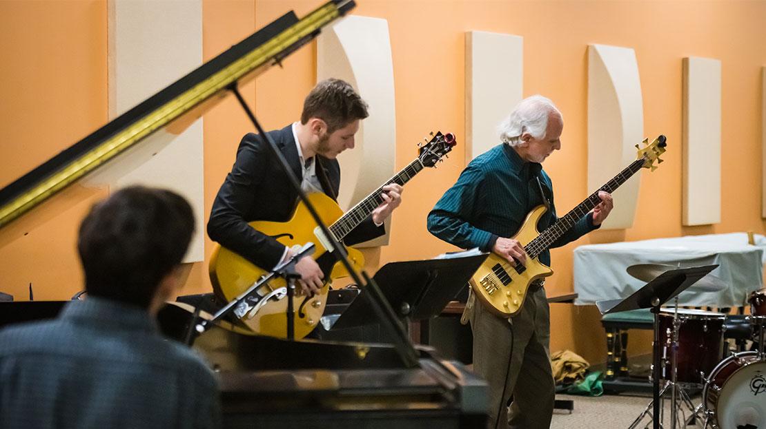 A student jazz ensemble performs a live concert featuring two guitarists.