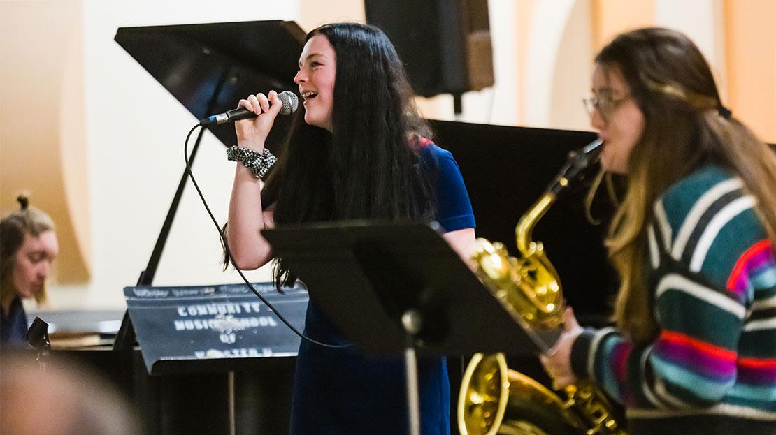 A student jazz ensemble performs a live concert with a vocalist and instrumentalists.