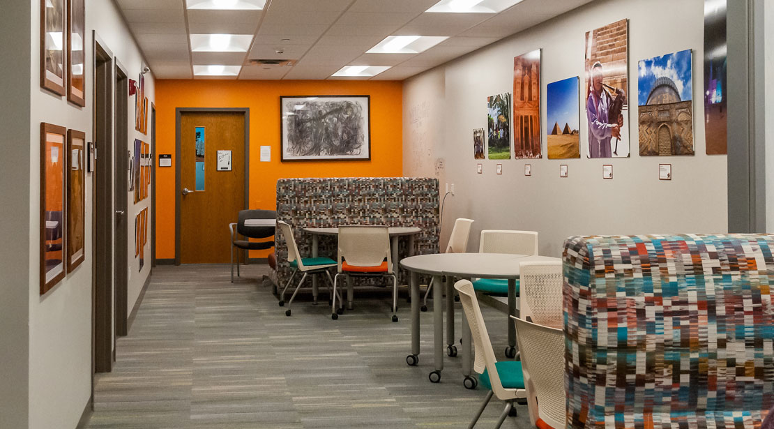 Around the corner from the front desk are tables with chairs and bench seats with tables for collaborative work, studying, writing support, and more.