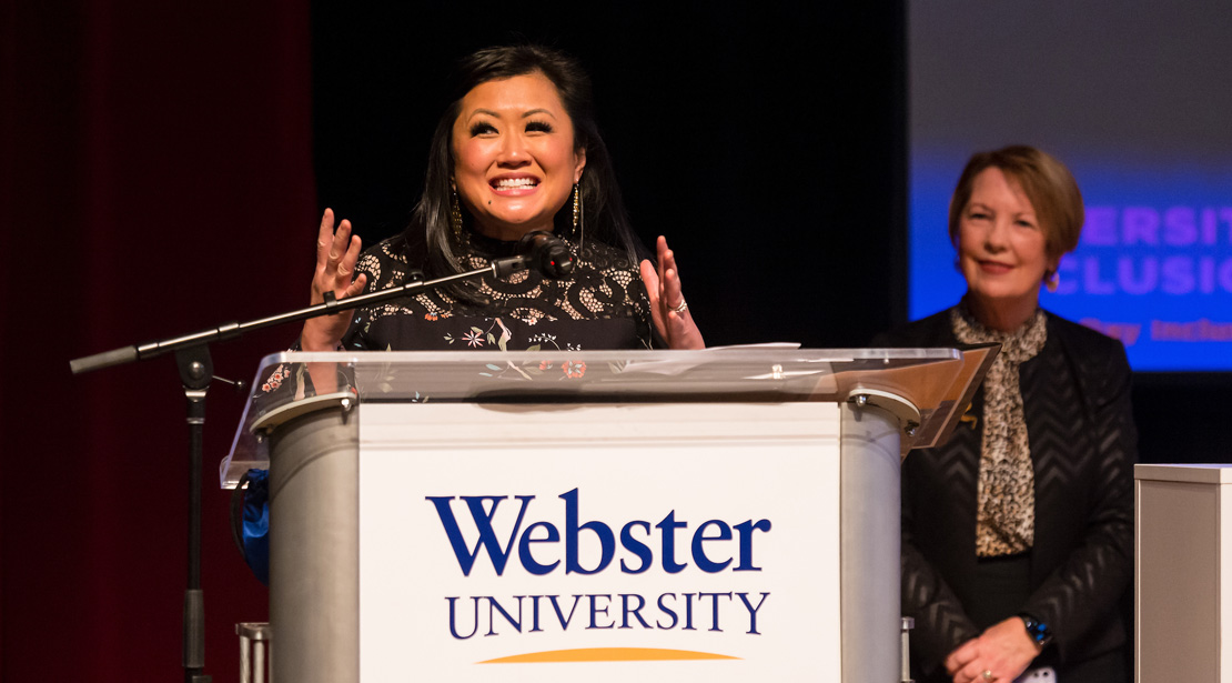 Michelle Li stands at the podium with Chancellor Beth Stroble in the background