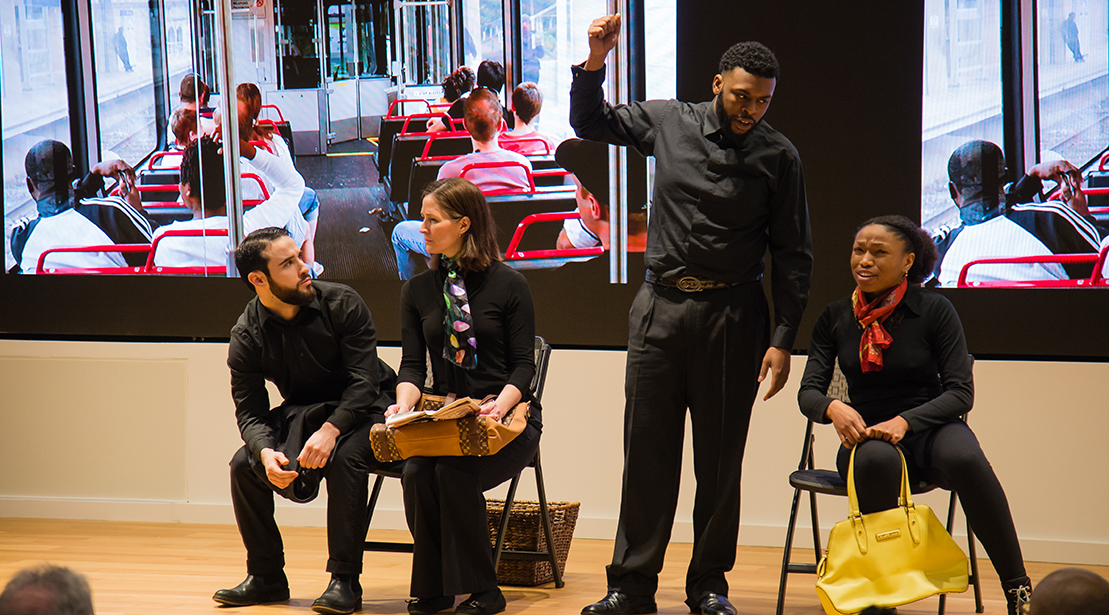 four actors on stage acting out a scene from a bus ride