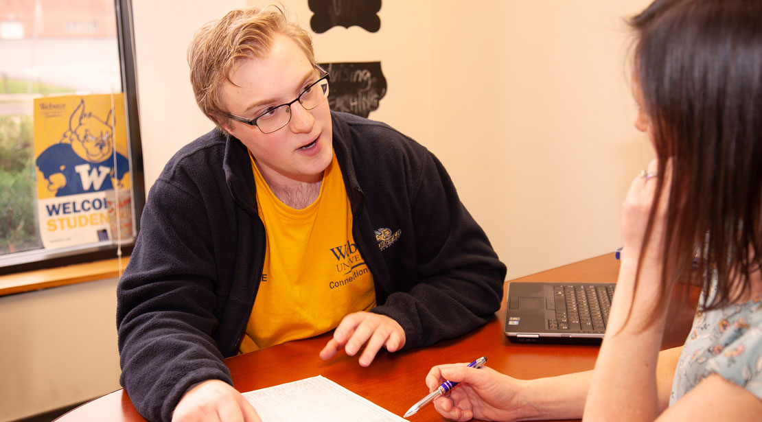 Webster student talking over college plan with an academic advisor.