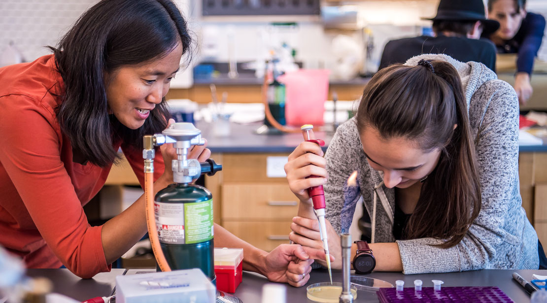 Dr. Preuss mentoring a Webster student on pipetting technique.