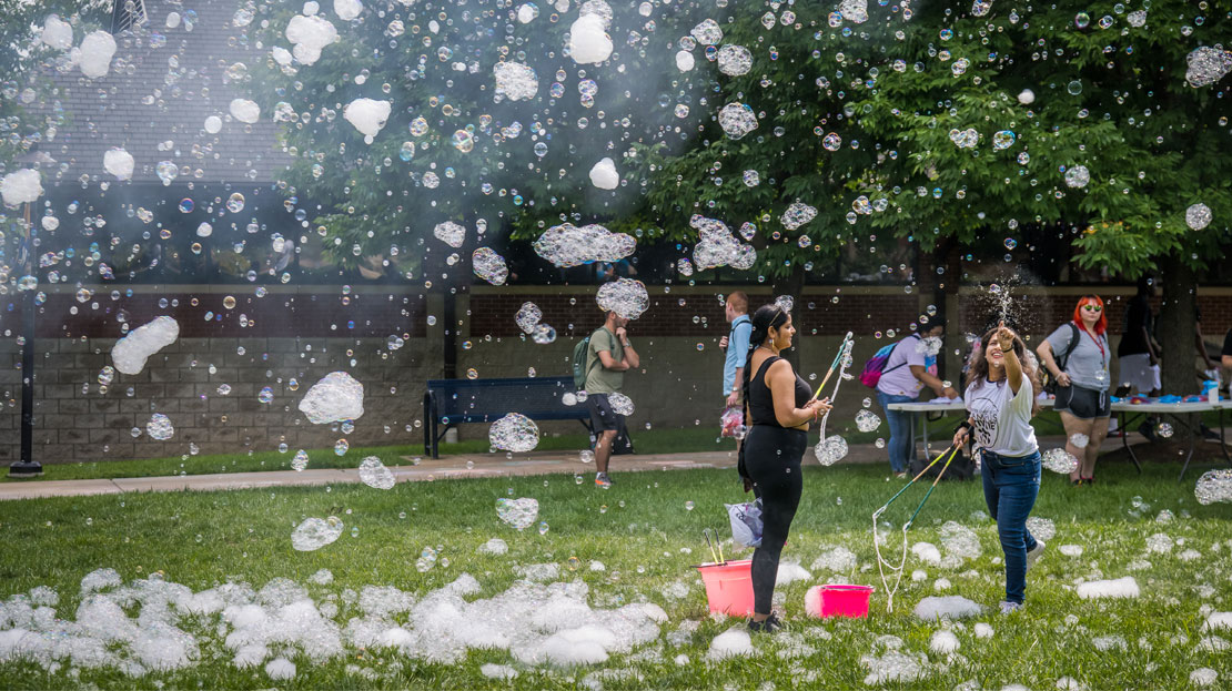 Students play in the flying bubbles from the Bubble Bus.