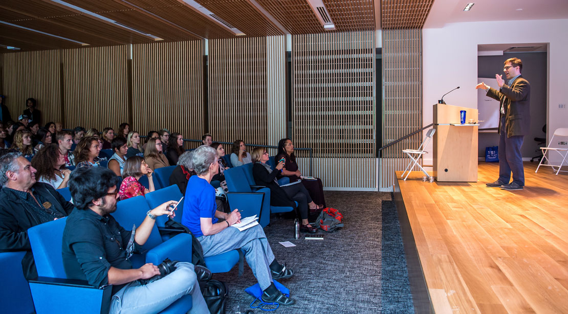 Side view of the speaker and audience at conference