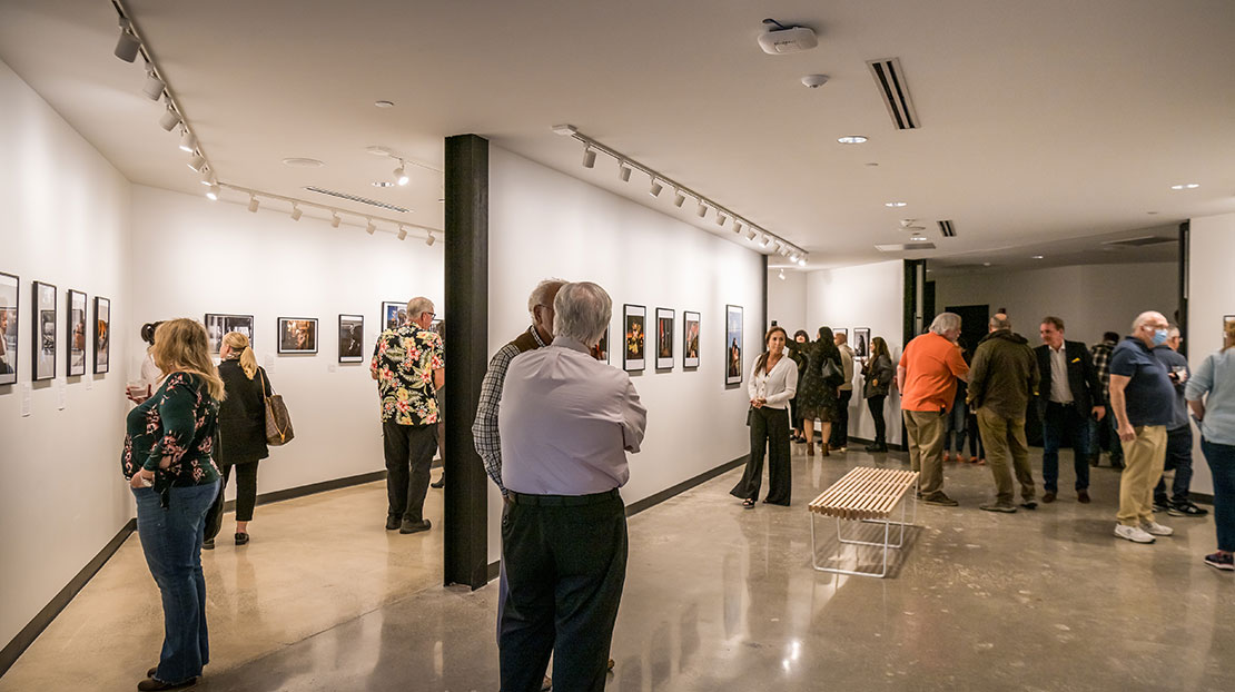 Kooyumjian Gallery show with photos on walls and people throughout