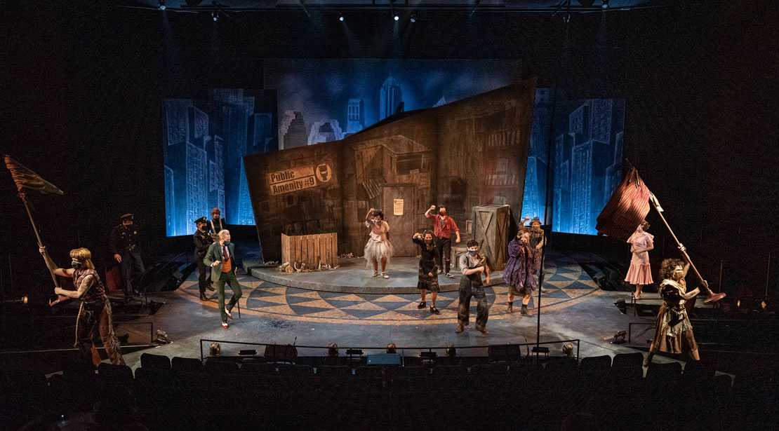 Stage-wide shot of the set with actors in costume