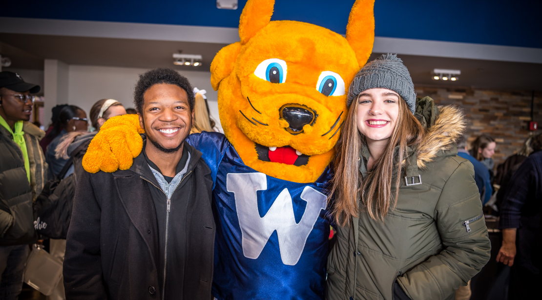 The Gorlok mascot poses with two students.