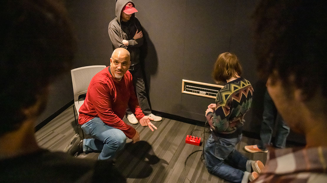 professor and student in sound room wiring up mixing box