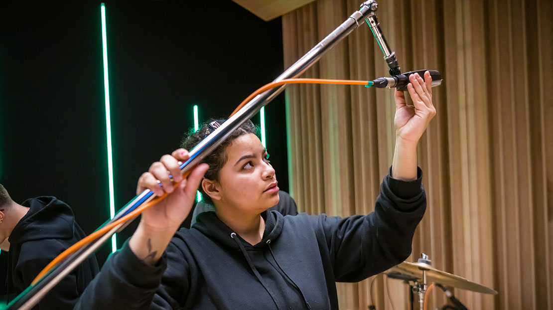 student adjusting overhead directional microphone