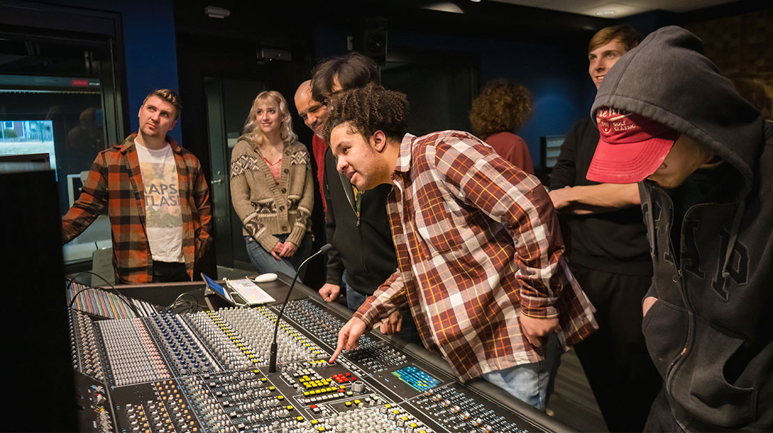 student testing the push-to-talk to sound booth button on AXS board