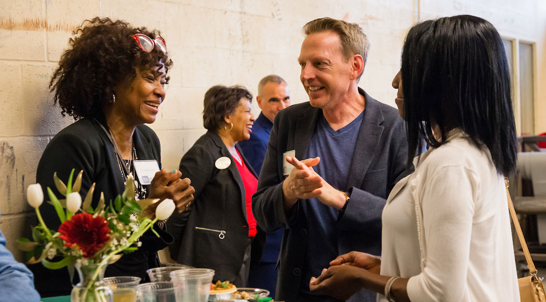 Alumni Vanessa Davis talks with a fellow alumna and a Webster faculty member