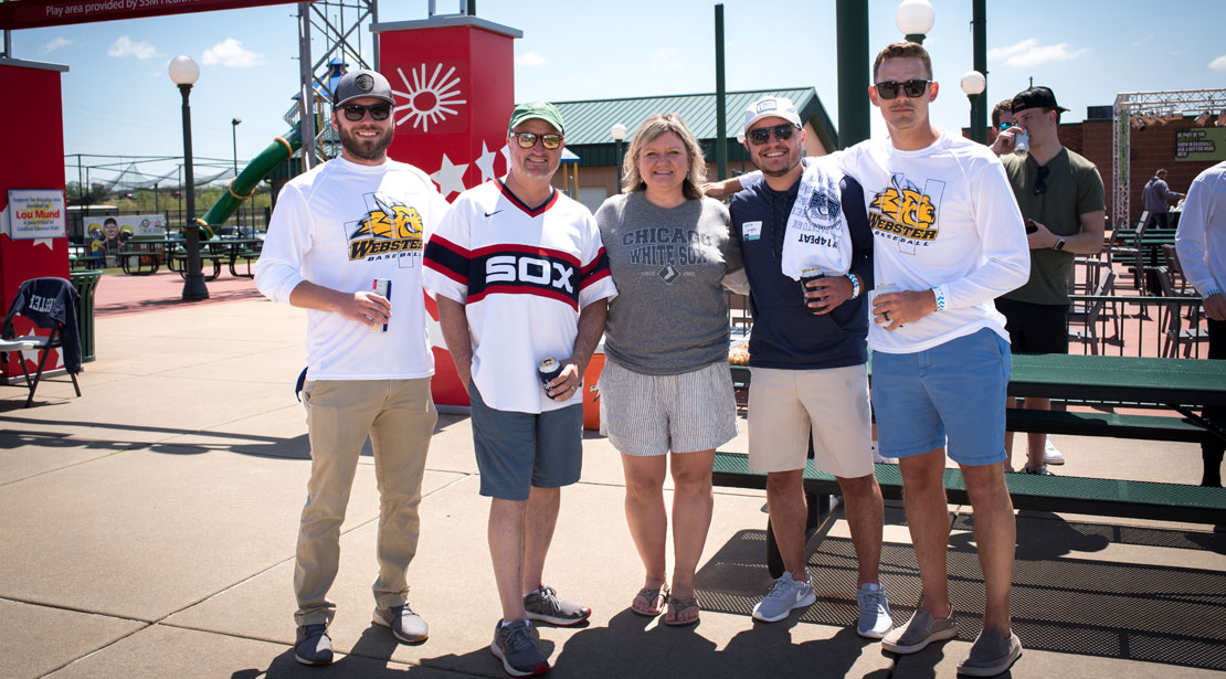 Five Webster alumni stand together at baseball game