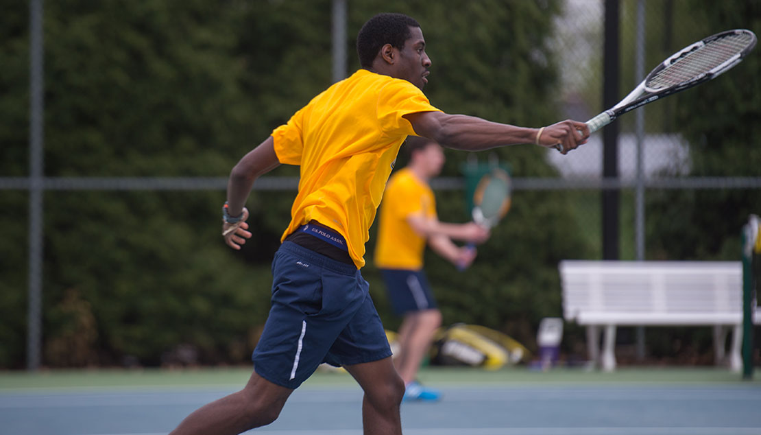 Male student playing tennis 