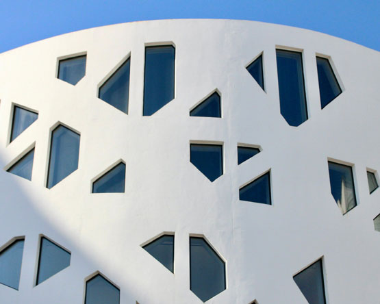 Rounded white building with geometric window cutouts