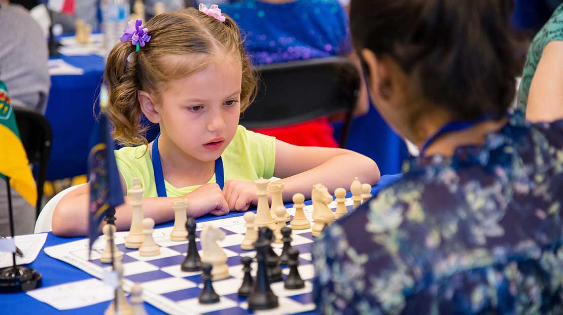 Young girl playing chess at camp