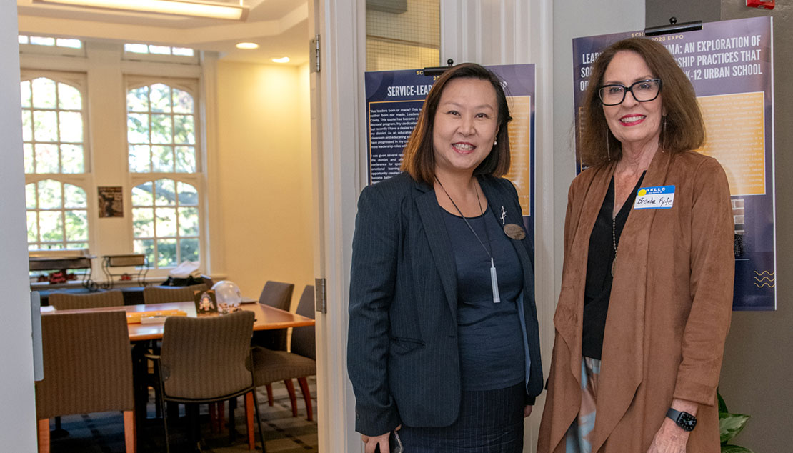 two faculty members prepare for the seo expo.