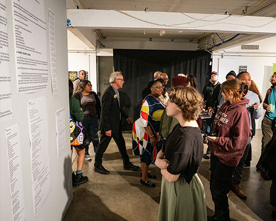 Attendee stands in front of wall covered in writings