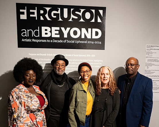 Five of the exhibitors pose together under Ferguson and Beyond exhibit opening wall