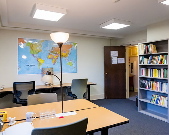 Room with desks, chairs, bookshelves and world map on wall