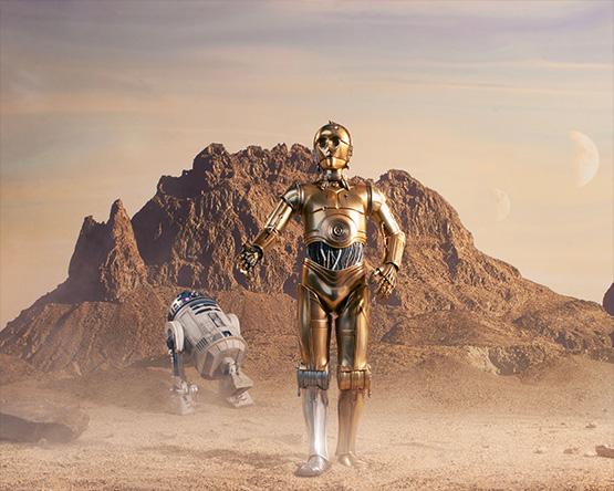 Droids R2D2 and C3PO in a desert landscape