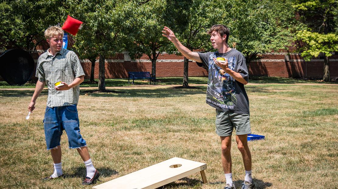 Students playing bags on the quad.