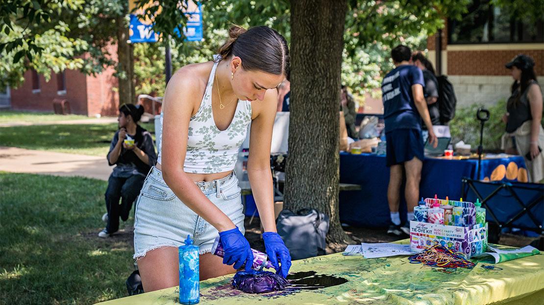A student making a tie-dye garment.