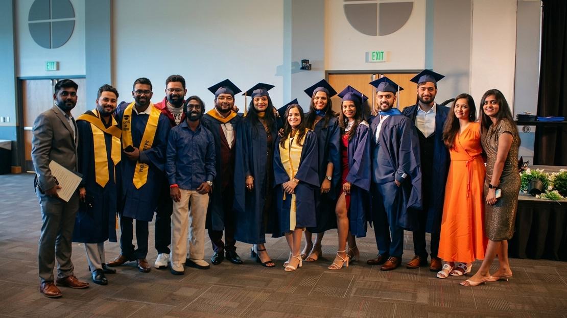 A large group of graduates pose for a photo.