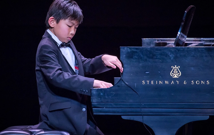 side view of Jerry Chang playing Steinway grand piano in 2018