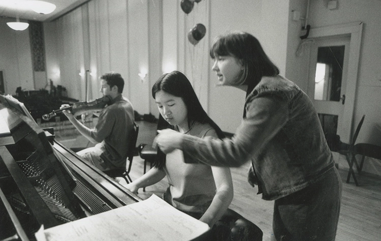 Vera Parking leaning over piano student