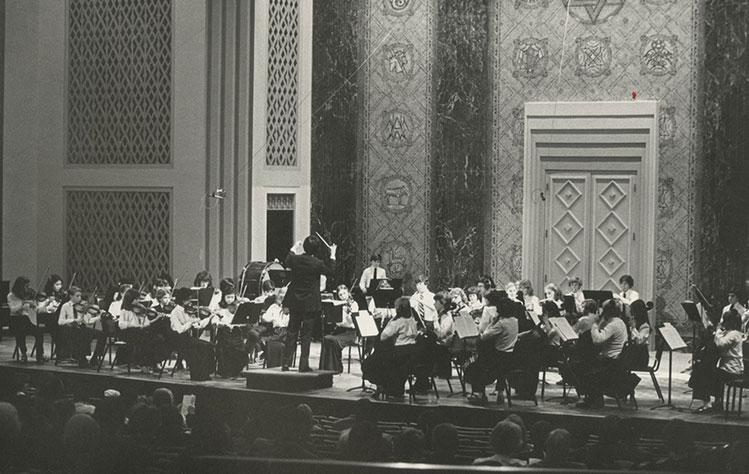 large concert hall with symphony and conductor