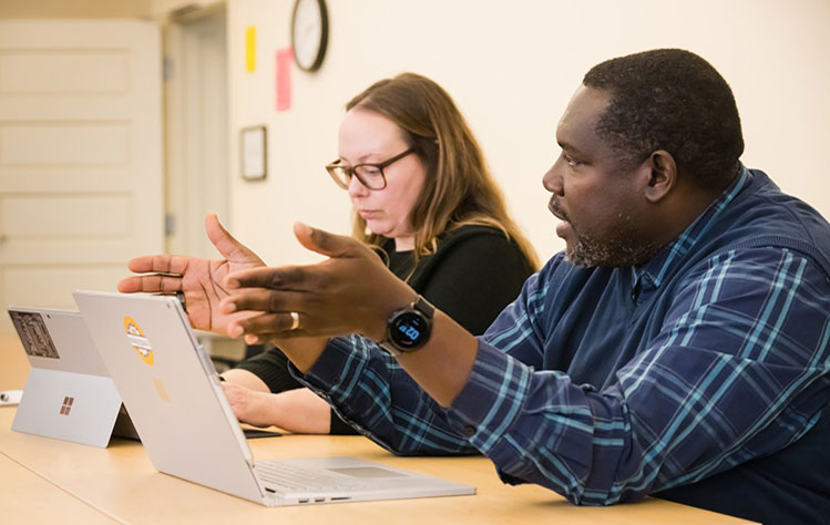 Professors in classroom having a discussion. 