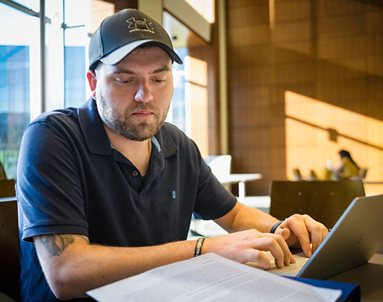 A man taking notes on a laptop.