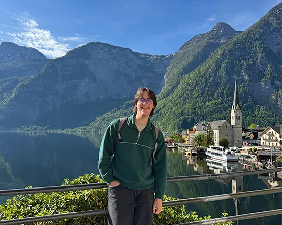 Student photographed in front of lake and mountains