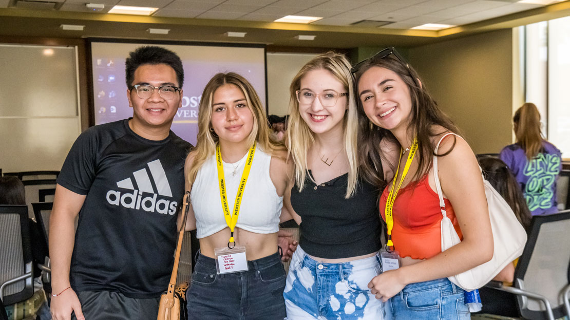 A group of Webster students pose together for a photo in a classroom.