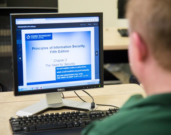 Male student in military fatigues working on a laptop for an online class.